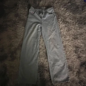 Ljusblå jeans - Säljer ett par grå jeans från märket Give Up. De har en klassisk design med fem fickor och en knappgylf. Perfekta för en avslappnad stil och passar till det mesta i garderoben. Sköna och stilrena för vardagsbruk.