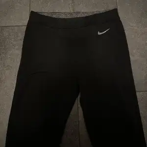 Säljer ett par svarta leggings från Nike i storlek S. De är perfekta för träning med sin tighta passform och bekväma midja. Materialet är mjukt och stretchigt, vilket gör dem idealiska för både gymmet och vardagsbruk. Nike-loggan syns diskret på sidan. Passa på att köpa dessa snygga och funktionella leggings!