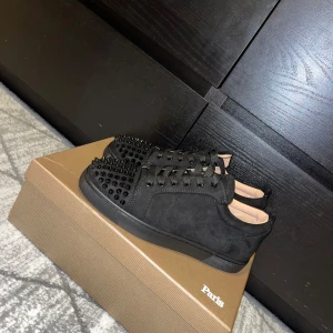 Svarta Christian Louboutin - DET ÄR STORLEK 39 MEN PASSAR 40!      Säljer ett par svarta Christian Louboutin skor i nytt skick. Skorna har en najs design på ovansidan och den ikoniska röda sulan.  Kommer med originalförpackning som har en liten skada och kvitto. Pris kan diskuteras vid snabbt köp!!