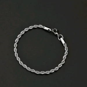Silverfärgat tvinnat armband - Snyggt och stilrent armband i silverfärg med en tvinnad design. Perfekt för både vardag och fest. Armbandet har en säker låsmekanism som gör det enkelt att ta på och av. Passar bra till olika outfits och ger en elegant touch.