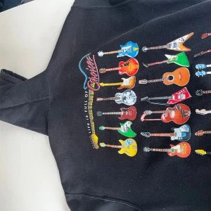 Svart hoodie med tryck - Svart hoodie i medium med ett gitarr tryck