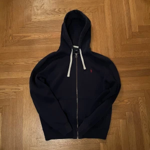 Polo Ralph Lauren Zip Up Hoodie - Säljer nu denna äldre och eftertraktade polo zip up från runt 90-talet då den är lite för stor på mig. Tröjan är i mycket bra skick med knappt några defekter alls.  Hör av er vid ytterligare frågor!