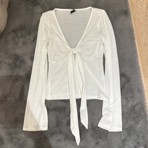 Gina Tricot - Söt topp från gina tricot i stl XS. Inga defekter och oanvänd. Kan knytas själv och även kan användas med tröja/linne under eller bara toppen. 🤍🤍🤍