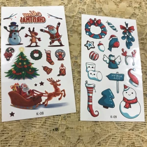 Julklistermärken  Tatuering  - Säljer ett set med julklistermärken / Tatuering som har olika festliga motiv som tomtar, renar, julgranar och snögubbar. Perfekt för att dekorera julkort eller presenter. Klistermärkena har glada färger och detaljer som gör dem extra speciella för julen. 🎄🎅. 35kr/2st 