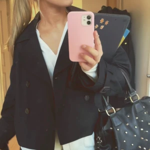 Kort trenchcoat  - Säljer en stilren mörkblå kappa i mycket bra skick. passar både till vardags och fest. Liten i storleken men den är superbekväm att ha på sig. Jag är 173 som referens och brukar ha S. Nypris 550kr säljer för 300 