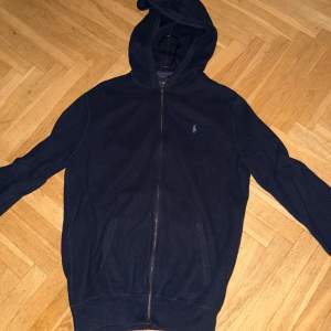 Säljer en snygg mörkblå hoodie från Ralph Lauren i Pima Cotton. Den har en dragkedja framtill och en klassisk broderad logga på bröstet. Perfekt nu när det är lite kallare ute!