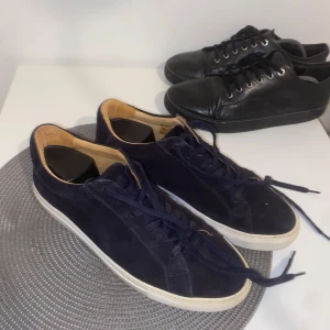 Mocha skor - Säljer två par sneakers i mycket bra skick. Ett par är svarta i skinn med snörning, perfekt för vardagsbruk. Det andra paret är A Days March skor i mörkblå  mocka med vita sulor, också med snörning. Båda paren säljs eller byts. Allt kan diskuteras 🤝