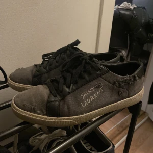 Saint Laurent - Säljer ett par gråa sneakers från Saint Laurent i bra skick. Originalbox är tyvärr borta men dustbags och extra original-snören medföljer. Storlek 39 men passar 40! PRIS KAN DISKUTERAS VID SNABB AFFÄR! Byten kan vara av intresse!