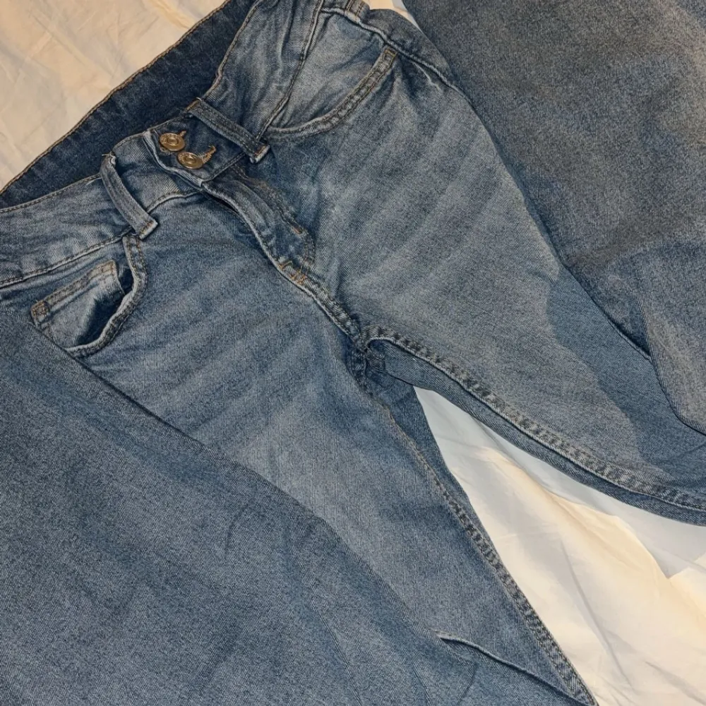 Säljer ett par slutsålda lågmidjade och utsvänga blåa jeans i bra skick. De är vintage med knappar på bakfickorna. Säljer då de är för små för mig💕. Jeans & Byxor.