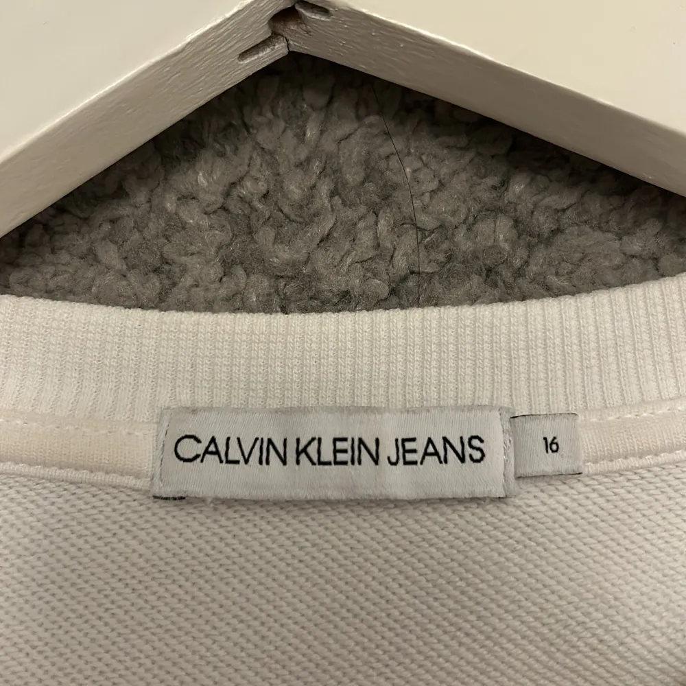 Säljer en stilren vit tröja från Calvin Klein Jeans. Den har långa ärmar med snygga svarta band där märket står i vitt. Perfekt för en casual look och passar till alla säsonger. Tröjan är i bra skick och är superbekväm! Orginal pris 550kr. Tröjor & Koftor.