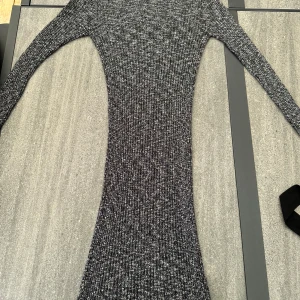 Grå stickad klänning från BikBok - Säljer en superfin grå stickad klänning från BikBok i storlek S. Den är tight och perfekt för höst och vinter. Klänningen har en ribbad struktur som ger en snygg passform. Perfekt för både vardag och festliga tillfällen!