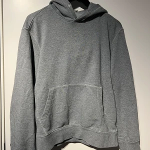Grå hoodie - Säljer en klassisk grå hoodie från arket i mycket bra skick. Den har en stor ficka fram och en bekväm huva. Perfekt för kyliga dagar eller mysiga hemmakvällar. Passar till det mesta och är superbekväm!