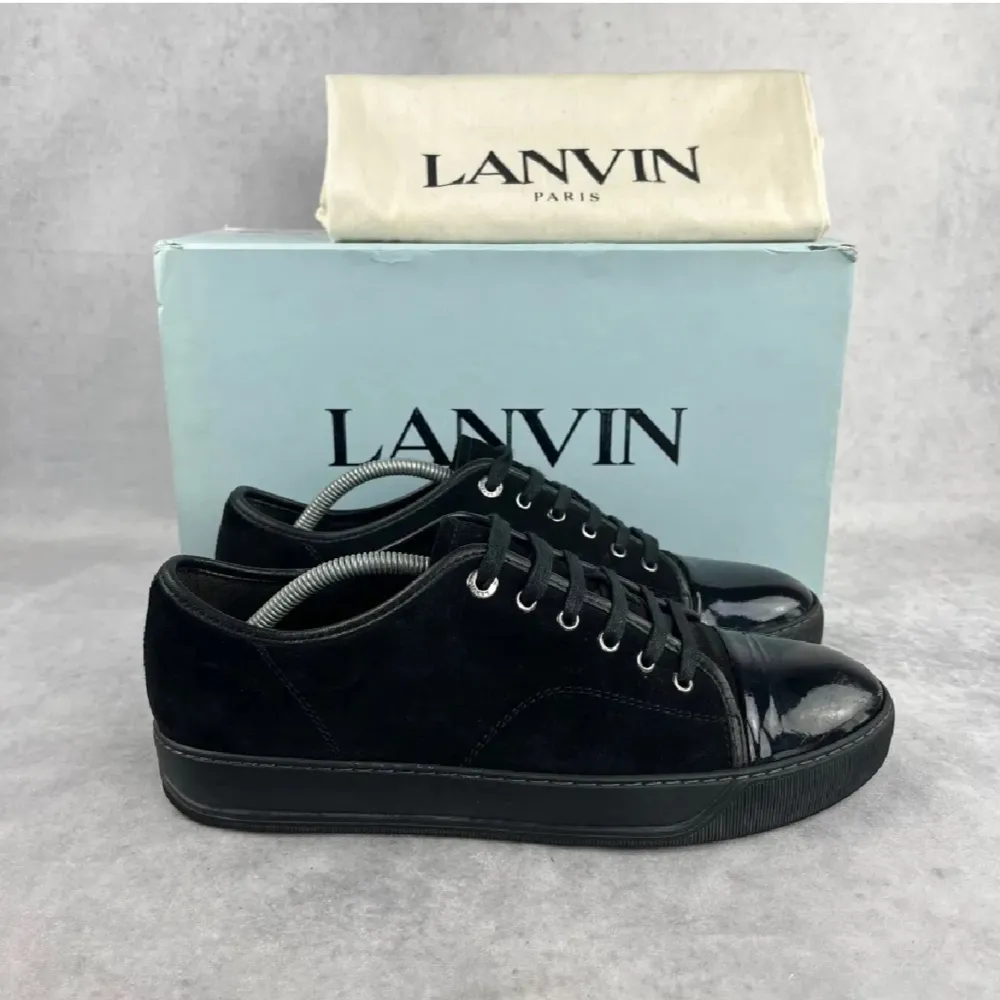 Snygga svarta sneakers från Lanvin i skinn och mocka. Storlek 41 passar 42-43. De har en stilren design med snörning och en glansig tådel. Perfekta för både vardag och festliga tillfällen. Obs. Endast dustbag, Skick: 7,5/10. Pris går att diskutera!. Skor.