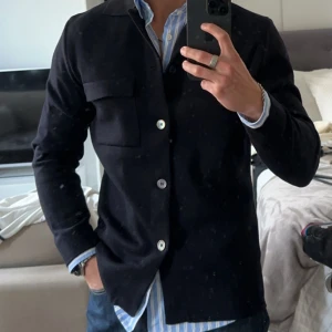 Svart kavaj med knappar - Galet snygg stickad cardigan i 100% merinoull från Stenströms. 10/10 nyskick endast använd 1-2ggr. Jag är 180 på 75kg och har storlek M. Nypris 3000kr. Kan fixa fler bilder