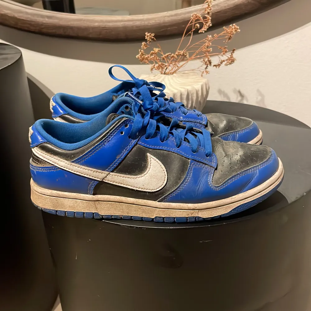 Säljer ett par blå och svarta Nike sneakers i bra skick. De har en vit Nike-logga på sidan och snörning framtill. Perfekta för vardagsbruk eller träning. Lite slitna men fortfarande snygga och bekväma. Skriv vid minsta lilla fundering. Kengät.