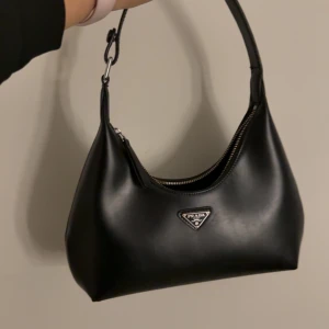 Svart axelväska  - Snygg svart axelväska som är köpt secondhand på vinted, dragkedjan är dålig men annars är fen i mycket bra skick