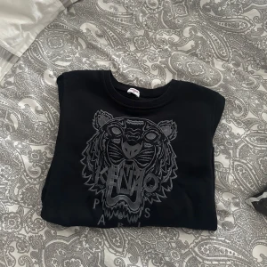 Svart tröja från Kenzo med tigerbroderi - Säljer en svart tröja från Kenzo i storlek M (sitter som en Xs/s) . Tröjan är perfekt för både höst och vinter. Den är endast testad. 
