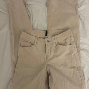 Beige Jeans - Säljer ett par snygga bootcut beige manchesterbyxor i bra skick. De har en klassisk femficksdesign och är perfekta för höst och vinter. Byxorna har en normal passform och är gjorda i mjukt manchestertyg.