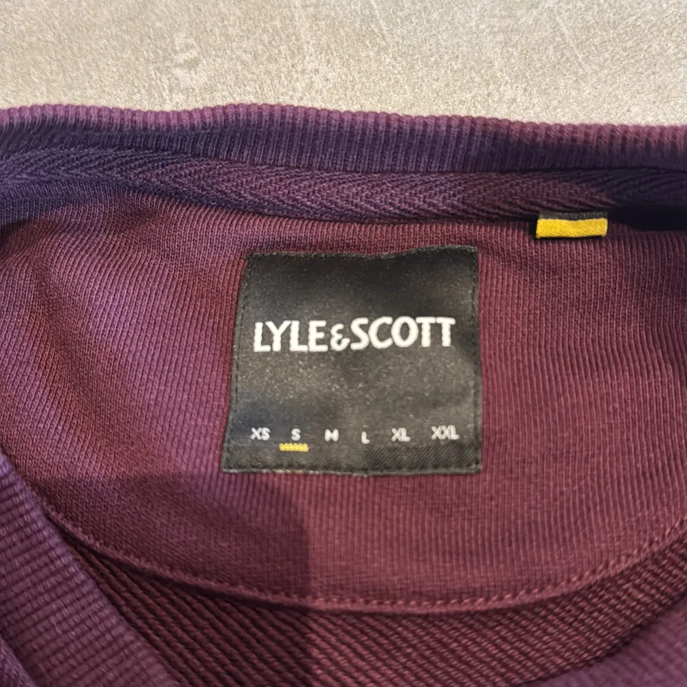 Säljer en snygg vinröd tröja från Lyle & Scott i storlek S. Tröjan har en liten gul logga på bröstet och är perfekt för både höst och vinter. Den är i mycket bra skick!. Tröjor & Koftor.