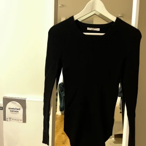 Svart ribbad tröja från Wera - Säljer en stilren svart ribbad tröja från Wera i storlek XS. Perfekt för både vardag och fest med sin enkla men eleganta design. Tröjan har långa ärmar och en rund halsringning. Passar perfekt till höst- och vintergarderoben!