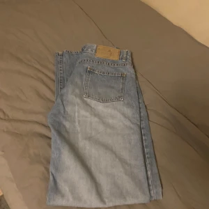 Jeans W32/L34 - Säljer ett par jeans i bra skick. Det är storlek W32/L34 och de är straight fit. De passar bra till vardagsanvändning. De är inte använda många gånger av mig. De har haft en tidigare ägare men det märks knappt. Bara lite små slitagenärken längst ner som syns på sista bilden. 