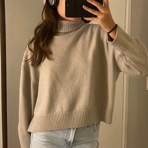 Stickad tröja - Beige stickad tröja från h&m i storlek M. Hög krage