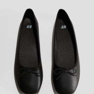 Svarta ballerinaskor från H&M - Snygga och klassiska svarta ballerinaskor från H&M. De har en söt liten rosett på tån och är perfekta för både vardag och fest. Har ej använt dom bara testat💗