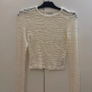 Vit stickad tröja från Bershka - Säljer en superfin vit stickad tröja från Bershka. Den är långärmad och har ett genomskinligt zebra mönster. Tröjan är i mycket bra skick och aldrig använd🦓