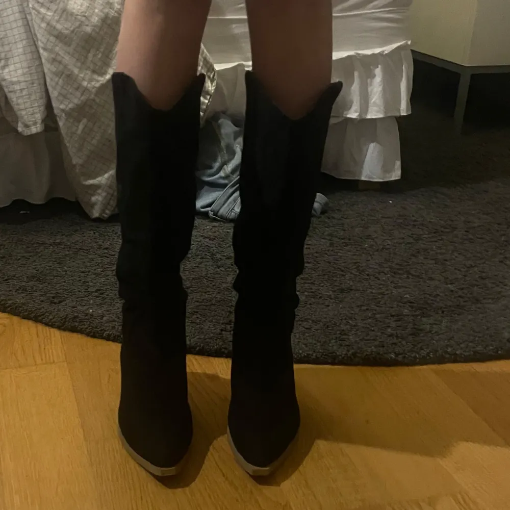 Snygga svarta stövlar i mocka med en rejäl klack. Perfekta för höst och vinter, dessa boots har en spetsig tå och ger en elegant look. De är i mycket bra skick och passar perfekt till både vardag och fest. Köpte eftersom att de var svin snygga men jag aldrig fått ett tillfälle att använda de, alltså är de aldrig använda!💗. Skor.