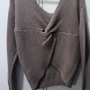 Beige stickad tröja från Streetwear Society - Säljer en superfin beige stickad tröja från Streetwear Society. Den har en unik twist-detalj som ger en cool look. Tröjan är långärmad och perfekt för höst och vinter. Den är både varm och stilren, perfekt för att hålla sig mysig under kyliga dagar 