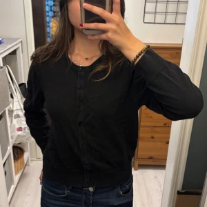 Svart kofta med knappar - Säljer en klassisk svart kofta i storlek M. Den har långa ärmar och knappar hela vägen fram. Perfekt för både vardag och fest! 🖤