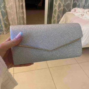 Kuvertväska - Säljer min väska jag hade på balen. Den är som ny då den endast användes under min bal. Det är en silver glittrande färg🩷