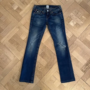 True Religion Billy - as snygga jeans från true religion med sköna distressings som ger karaktär till detta plagg. storlek 26. skickas i befintligt skick och kan ses på bilderna.  skriv om på DM om ni har fler frågor! ⭐️ Midja: 35cm