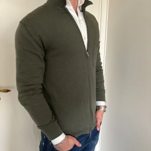 J. Lindeberg merino kofta grön  - -Kofta från märket J. Lindeberg i storlek M  - Material merino  - Bra skick, inga defekter förutom ett par lagade hål, syns ej - Modell på bild är 175/60kg.  - Hör av dig vid eventuella frågor! Mvh  