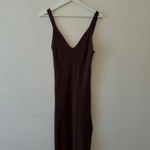 Brun ribbad klänning från Gina Tricot - Säljer en snygg brun ribbad klänning från Gina Tricot. Den har en tight passform och är ärmlös med breda axelband. Perfekt för både vardag och fest!