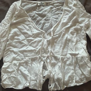 Vit somrig blus - Blus från hollister, har nästan aldrig använt den men den är dock köpt second hand.  Säljer då den är för liten för mig.  Den är väldigt tunn och skön att ha i sommar. Använd köp knapppen om du vill köpa och skriv om du har mer frågor💞
