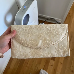 Kuvert väska från Carin Wester - säljer min kuvert väska jag hade på balen!! Den är som ny 💫 Beigh och blommig 