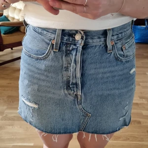 Jeanskjol Levi's - Jeanskjol från Levis med knappgylf, storlek 28 - motsvarar en small. Aldrig använd.