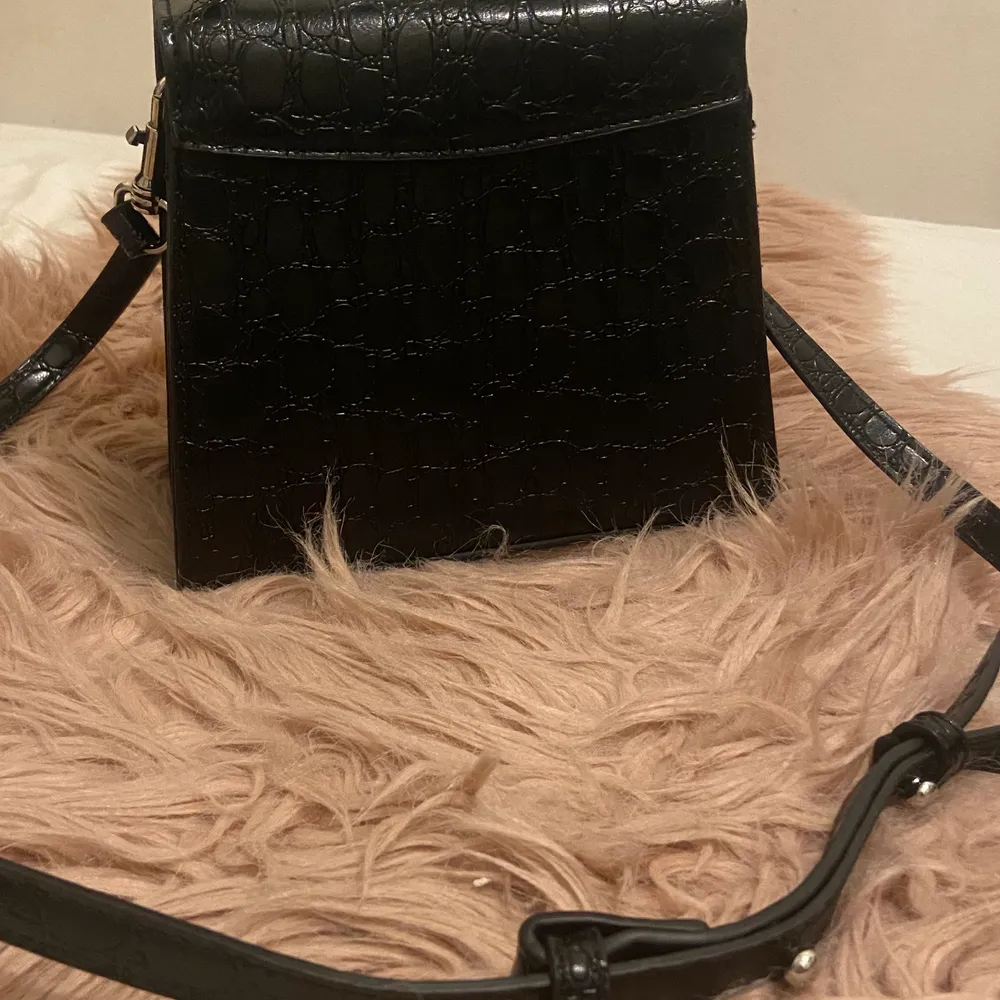 Jag säljer en svart krokodil väska som är i väldigt bra skick och kvaliten är jätte bra väldigt liten chans att den går sönder osv. . Väskor.