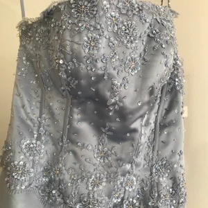 Balklänning/bröllopsklänning  - Begagnad balklänning /bröllopsklänning.står s8 som storlek . Lätt smutsig längst ner vid klänningen. Får ej tvättas i vanlig maskin .Dragkedjan på baksidan av klänningen (ryggen) krånglar . Nedre delen av klänningen har massa tyg under så att den ser större ut . Tyget bak på klänningen är lite längre .ena axelbandet är av . Fast vet inte om den är designad så . Man kan ju använda den utan banden också .Annars i gott skick . Kanske nåt för den händiga ? Kom med prisförslag! 