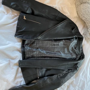 Skinnjacka storlek M (mer som xs/s)  - Äkta läder, svart. Skön insida. Mjukt läder. 3 fickor med dragkedja. Nypris 1500kr