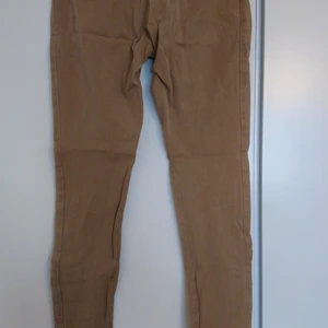 Byxor tighta - Beige byxor i tight modell, fickor med dragkedja fram och fusk fickor bak. Fraktkostnad blir nog lägre pga köper porto i appen