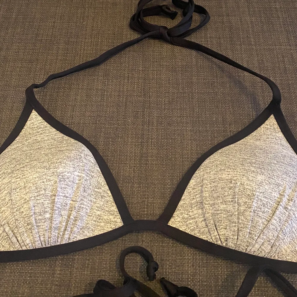  En grå bikini topp med knytning i nacke och rygg från H&M. Storlek XS. Är för liten på mig därav säljs den. . Övrigt.