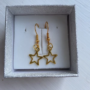 Halsband och örhängen  - Jättefina örhängen och halsband med stjärnor som är guldfärgade, 10%går till att hjälpa folk med psykisk ohälsa att få hjälp i tid🤍 tryck gärna inte på köp nu då det finns flera stycken och om du är student och kan visa mecenat eller studentkort = rabatt