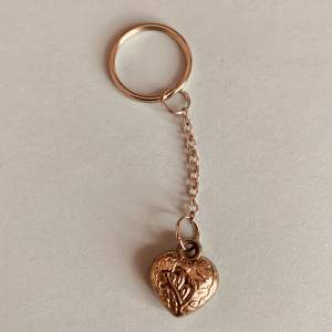 En nyckelring med ett hjärta i silver, hjärtat har två blommor och lite andra mönster i💕✨(smycke på 1.5cm) 30kr + 15kr frakt!!