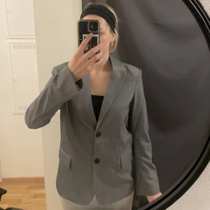 Grå kavaj - Nyskick! Använd en gång därför fortfarande veck i ryggen. Den är i storlek xs men skulle säga mer åt s