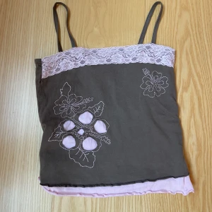 Linne - Linne som är köpt second hand men har aldrig använt det. Linnet ger lite y2k vibes och är brunt med rosa spets och detaljer. 