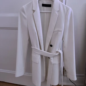 Kavaj  - En vit kavaj, använd 1 gång - nyskick. 