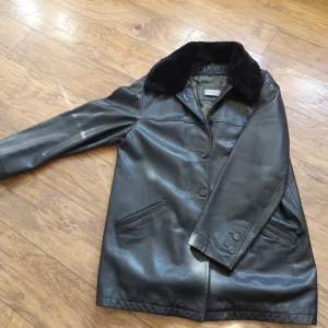 LÄDERKAPPA vintage - Läderkappa i äkta läder säljes. Fint skick, pälskragen (ej äkta päls) är avtagbar och vid köp medföljer även en tunnare jacka (sista bild) som fäst med dragkedja i jackan. Prisförslag mottages<3 vid frågar eller fler bilder skicka iväg ett meddelande❤️‍🔥
