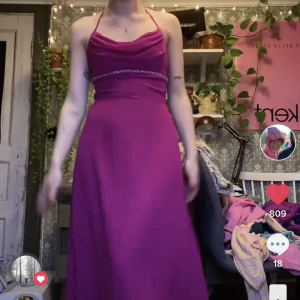 Balklänning  - Superfin balklänning jag köpte secondhand men som är för liten. Cerise färg med strass under brösten. Står ingen storlek men skulle säga att det är en mindre s. Den ger en superfin siluett på kroppen och går ner på marken på mig som är ca 165 vem 💕